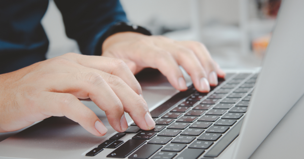 Picture of a computer keyboard with person's hands typing