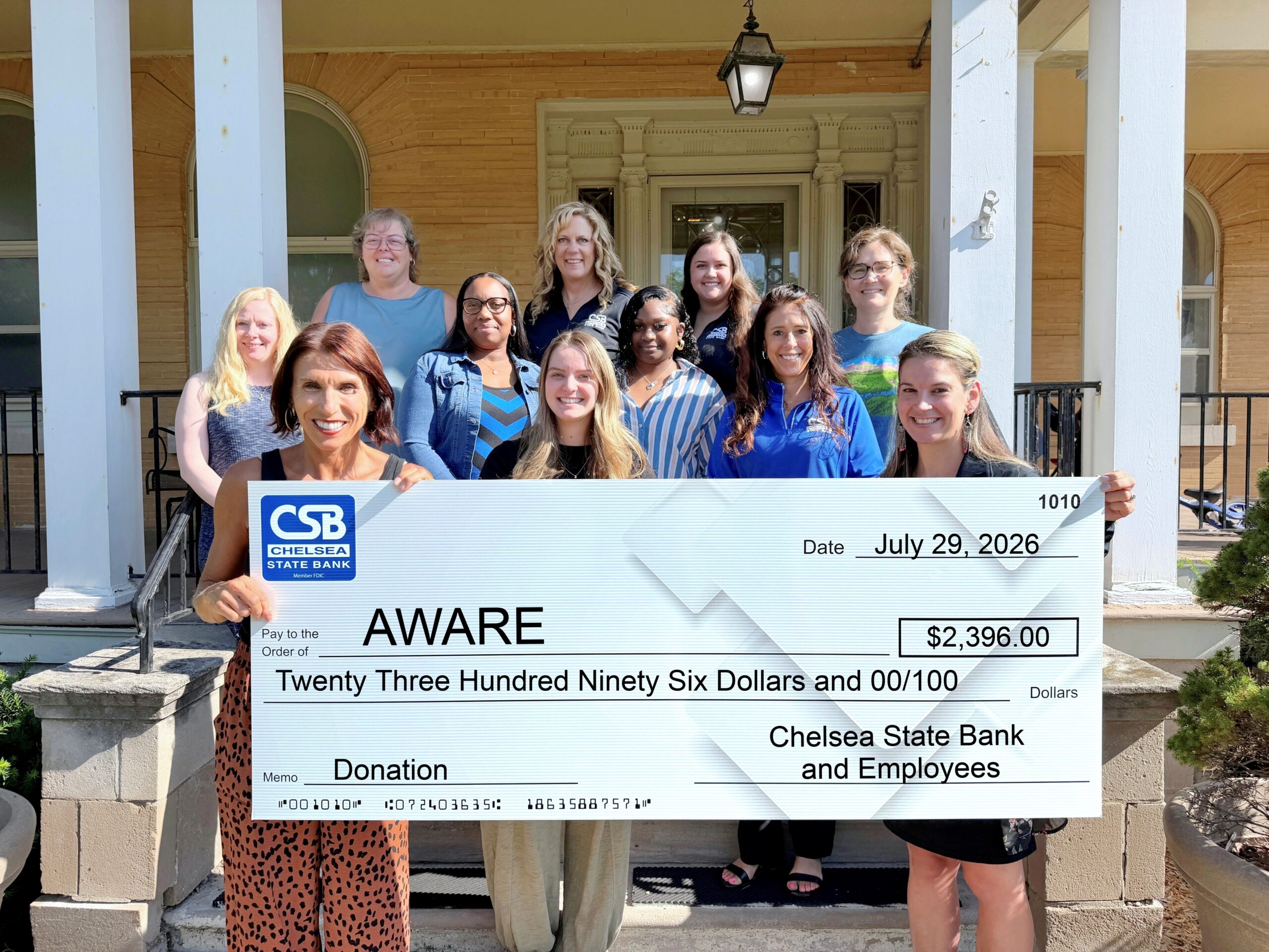 Aware Shelter's leadership team poses for a photo with Chelsea State Bank Team members